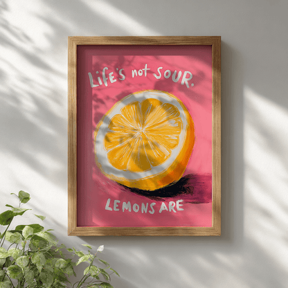 Quirky motivational lemon poster with vibrant yellow citrus and pink background displayed in wooden frame on white wall for modern wall decor

