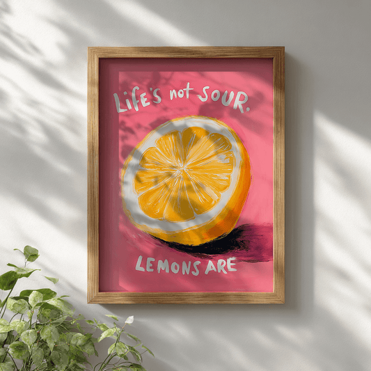 Quirky motivational lemon poster with vibrant yellow citrus and pink background displayed in wooden frame on white wall for modern wall decor

